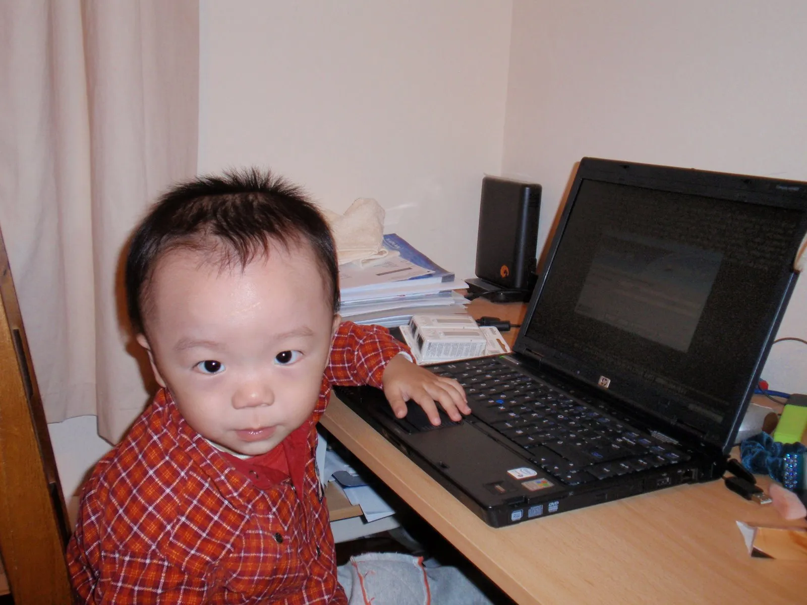 Weichen as a baby, sitting beside a laptop