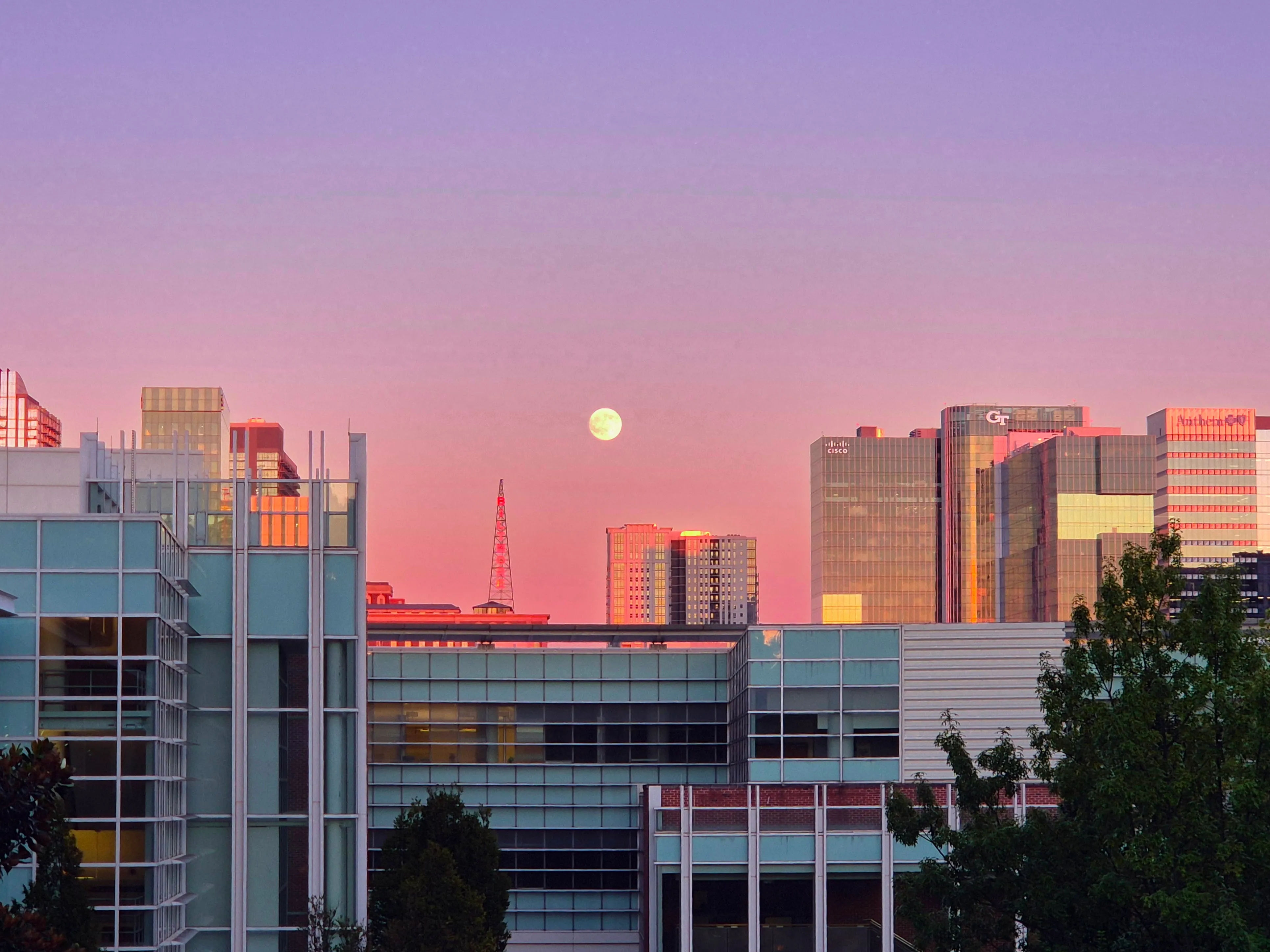 The moon rising over Georgia Tech beneath a pink sky