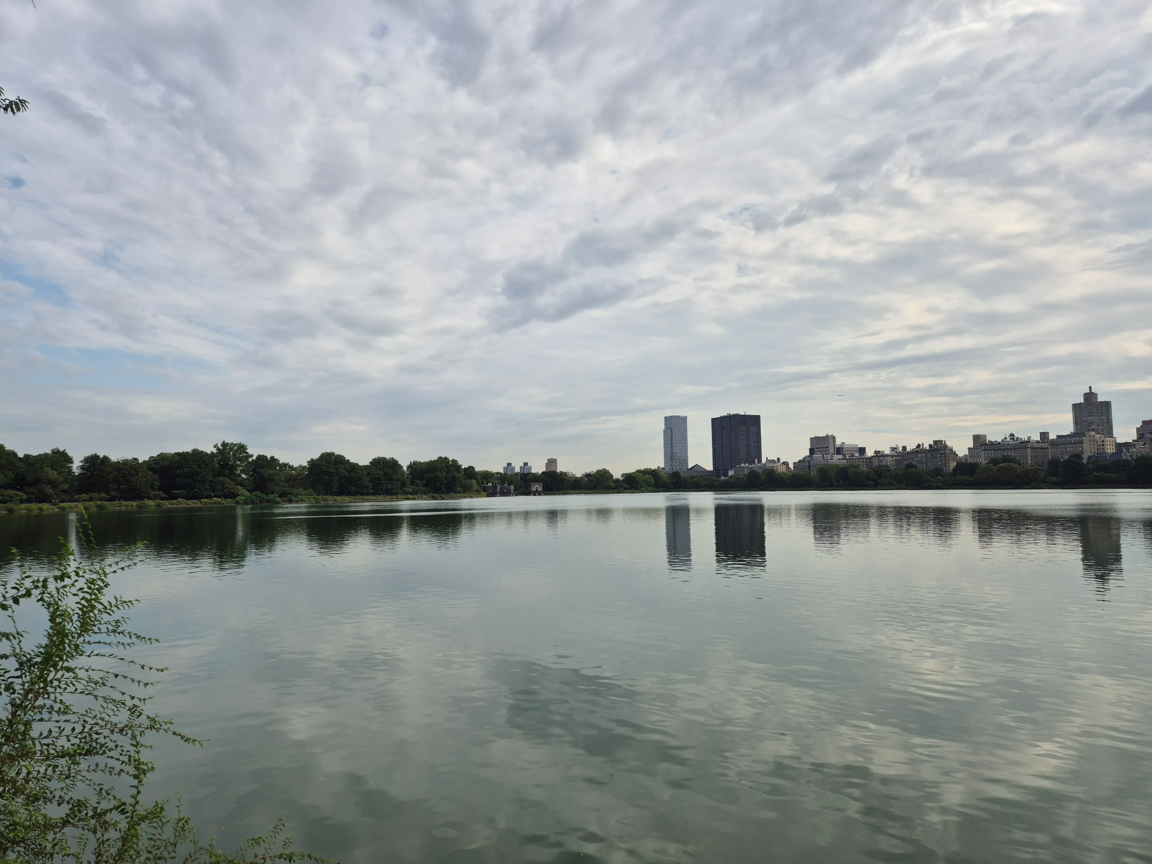 New York buildings reflected across a lake in Central Park